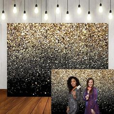 two women standing next to each other in front of a wall with glitter on it