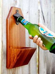 a person opening a bottle opener on a wooden wall