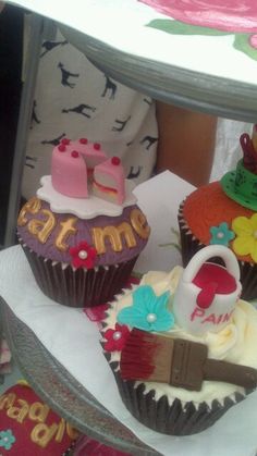 three decorated cupcakes sitting on top of a table