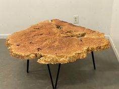 a table made out of wood with hairpin legs on the floor in an empty room