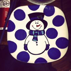 a blue and white polka dot toilet seat with a snowman painted on it