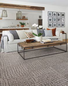 a living room filled with furniture and decor on top of a white carpeted floor