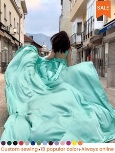 a woman in a blue dress is walking down the street with her back to the camera