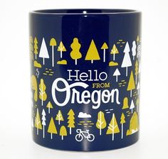 a blue coffee mug with yellow trees and the words hello from oregon printed on it