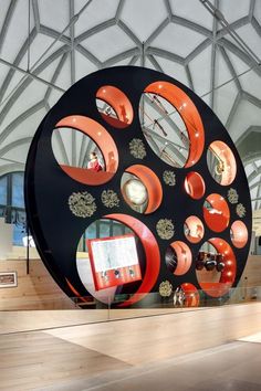 a large circular sculpture with many mirrors on it's sides in a museum like setting