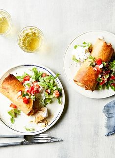 two white plates topped with food next to silverware