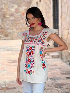 This Beautiful Hand embroidered blouse has a unique Mexican inspired Floral design and flirty ruffle sleeves. The blouse is a fresh cotton linen embroidered with cotton string. Paired with your favorite pair of jeans or a cute pair of shorts, the Floral Embroidered Elba Top is a Solei favorite. This distinctive embroidery design originated in Puebla, Mexico. We have a deep appreciation for these beautiful works of art and the artisans who create them. With your help, we will support the preserva Mother's Day Promotion, Multicolor Blouse, Hand Embroidered Blouse, Embroidered Tops, Mexican Party Theme, Mexican Blouse, Multi Color Blouse, Cotton String, Embroidered Clothes