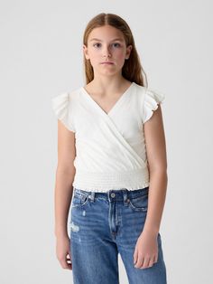 Soft cotton blend top.  V-neck.  Short flutter sleeves.  Wrap detail at front.  Smocked hem.  Slim fit.  Hits at the hip. Kids Wrap, Kids Wraps, Gap Kids, Flutter Sleeves, Wrap Top, Flutter Sleeve, Smocking, Gap, Cotton Blend