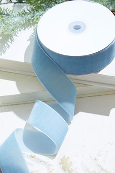 a roll of blue ribbon sitting on top of a window sill