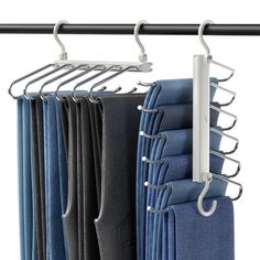 several folded jeans hanging on a metal rod