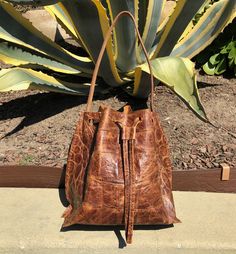 croco embossed cow leather color: bourbon brown lining: raw unlined dimensions: 9.5"h x 9.5"w x 6.5"d handle drop: 10" light weight One of a kind handmade in Los Feliz, CA Brown Textured Leather Bucket Bag With Double Handle, Cognac Textured Leather Bucket Bag, Casual Leather Shoulder Bag With Crocodile Pattern, Brown Leather Bucket Bag With Textured Leather, Brown Leather Shoulder Bag With Crocodile Pattern, Brown Bucket Bag With Leather Lining And Double Handle, Brown Textured Leather Bucket Bag For Shopping, Brown Leather Lined Bucket Bag With Double Handle, Cognac Textured Leather Bucket Bag For Daily Use