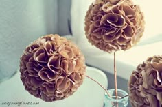 two vases filled with flowers sitting on a table next to a window sill