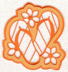 an orange and white embroidered design with flowers on it's side, in the shape of a heart