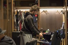 a man standing in front of a closet filled with clothes