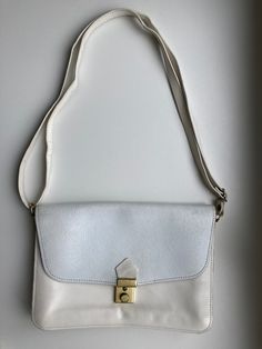 "♥ Vintage white crossbody bag, 2 compartments and 1 pocket inside and 1 pocket outside. ♥ Beautifully engraved front flap with floral botanical pattern.  ♥ At least partly genuine leather. ♥ Adjustable strap. ♥ There is some leather wear and discolorations inside and outside (see the photos).  Measurements: - width 9.9\" / 25cm - height 7.1\" / 18cm - depth 1\" / 2.5cm ♣ Vintage items may come with minor flaws due to pre-loved wear. Please enjoy and appreciate this item with its character. ♣ Fo Classic White Flap Shoulder Bag, White Everyday Flap Shoulder Bag, Everyday White Flap Shoulder Bag, Everyday White Rectangular Flap Bag, White Rectangular Flap Bag With Adjustable Strap, Cream Flap Bag For Daily Use, White Satchel Flap Bag With Detachable Strap, Cream Flap Shoulder Bag With Adjustable Strap, White Flap Bag With Adjustable Strap