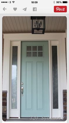 a blue front door with two sidelights and a lantern on the top of it