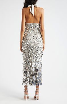 the back of a woman wearing a silver sequin dress