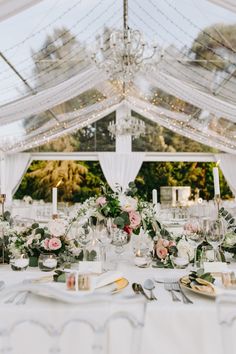 the table is set with white linens and flowers, candles, and napkins