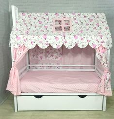 a white bunk bed with pink flowers and butterflies on the top, next to a brick wall