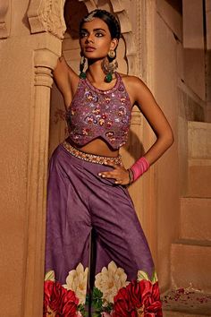 Lilac, multi colored sharara featuring floral designs. Comes with an intricately embroidered padded lilac blouse with heavy tassels and doris.
Components: 2
Type Of Work: Floral
Neckline: Round
Sleeve Type: Sleeveless
Fabric: Raw Silk
Color: Purple,Multi Color
Other Details: 
Backless with tassel tie-ups
Length:
Blouse: 14 inches
Sharara: 44 inches
Model height: 5ft 8inches, wearing size S
Note: All the jewellery worn by the model and the red outfit worn by the other model is not for sale
Occasi Lilac Sharara, Lilac Blouse, Sharara Pants, Sharara Set, Red Outfit, Embroidered Blouse, Raw Silk, Bold Fashion, Floral Designs