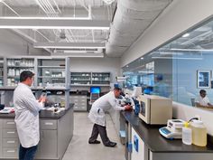 two men in lab coats working on equipment