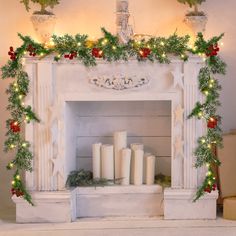 a fireplace decorated for christmas with candles and greenery