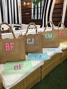 three burlap bags with different colored letters on them sitting on top of each other