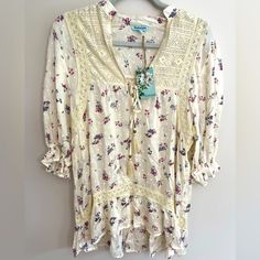 Nwt Nostalgia Floral Print Top Size Small. Beautiful Cream Color Background With Blue And White Flowers Spread Throughout. V-Neck Top With Some Crochet-Like Designs Throughout. Elastic At The Ends Of The Sleeves, Which Land Right At About Elbow Length. Perfect To Dress Up Or Down With. Cheap Cotton Tops With Ditsy Floral Print, Floral Print Tops, Blue Cream, V Neck Tops, Cream Color, White Flowers, Tunic Tops, Floral Prints, Dress Up