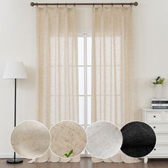 four white and black chairs sitting in front of a window next to a lamp on top of a hard wood floor