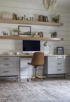 a desk with a computer on top of it in front of some bookshelves