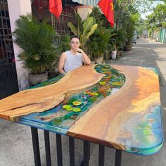 a man sitting at a table made out of wood and glass