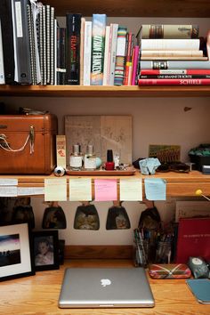 an apple computer sitting on top of a wooden desk next to a bookshelf