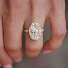 a woman's hand with a diamond ring on top of her finger and an engagement band