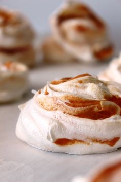 some kind of dessert with icing on top of it and other pastries in the background