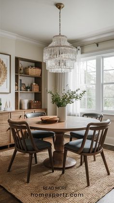 a dining room table with four chairs and a chandelier hanging from the ceiling