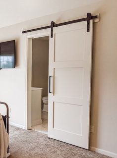 a bed sitting in a bedroom next to a flat screen tv on top of a wall