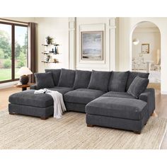 a living room with a sectional couch and ottoman