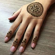 a woman's hand with henna tattoos on it