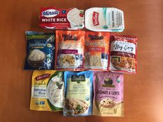 several bags of food are laid out on a wooden table, including rice and other foods