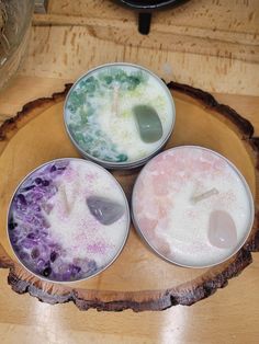 three bowls filled with different colored liquid on top of a wooden table next to a frying pan