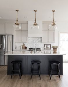 35 Stunning Off-White Kitchen Cabinets For A Spacious Look All White Kitchen With Black Island, Cream And Black Cabinets Kitchen, Cream Cabinets Black Island, Black Island White Kitchen, Moody Kitchen White Cabinets, Kitchens With Black Islands, Black And Off White Kitchen, Black Kitchen White Countertops, Black Bottom Cabinets White Upper