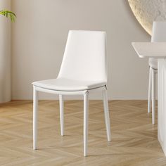 a white chair sitting on top of a hard wood floor next to a table and chairs