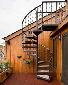 a metal spiral staircase next to a wooden building