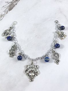 This fun charm bracelet is the perfect accessory to showcase your love for Athena, Greek goddess of wisdom. Charms included: Helmet Owl Medusa Head Snake Spider 5 Lapis Lazuli gemstone beads are placed in between each charm. Comes in three sizes: Small: 6.5 inches (with extra rings at the end to expand up to 7.5 inches.) Standard: 7.5 inches Large: 8.5 inches Ships in a jewelry box so it's ready to be give as a gift. Choking Hazard: Small parts. Not intended for small children. Statue is for pho Spiritual Charm Bracelet With Dangling Charms, Spiritual Nickel-free Dangle Charm Bracelet, Goddess Greek, Athena Greek Goddess, Greek Goddess Of Wisdom, Greek Mythology Jewelry, Mythology Jewelry, Medusa Head, Greek Goddess