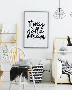 a white room with black and white decor on the walls, including a wooden rocking chair