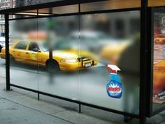 an advertisement on the side of a bus stop in new york city, with taxis and yellow cabs