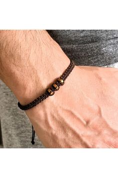 Elevate your style with our Handmade Unisex Macrame Weave Bracelet, featuring natural copper-colored hematite stones. This meticulously crafted accessory blends elegance with a touch of earthy charm, making it the perfect gift for yourself or a loved one. The adjustable macrame design ensures a comfortable fit for any wrist, while the shimmering hematite stones add a subtle yet striking accent. Embrace the harmony of handmade artistry and natural beauty--add this unique bracelet to your collecti Brown Hematite Jewelry Gift, Adjustable Brown Hematite Beaded Bracelets, Adjustable Brown Hematite Bracelet, Adjustable Hematite Brown Bracelets, Adjustable Gold Hematite Bracelets, Adjustable Brown Copper Braided Bracelets, Casual Brown Braided Bracelets With Round Beads, Casual Brown Macrame Beaded Bracelet, Casual Brown Macrame Bracelets