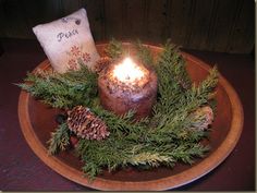 a candle and some pine cones on a plate