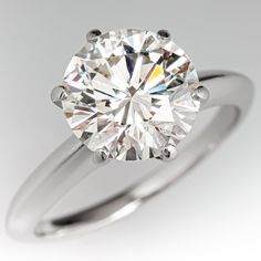 a round brilliant cut diamond ring on a white background, with the center stone visible