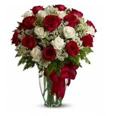 a vase filled with red and white flowers